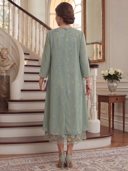 Robe trapèze/princesse en mousseline grande taille pour mère de la mariée : encolure ronde, manches 3/4, longueur mi-mollet, avec volants et broderies